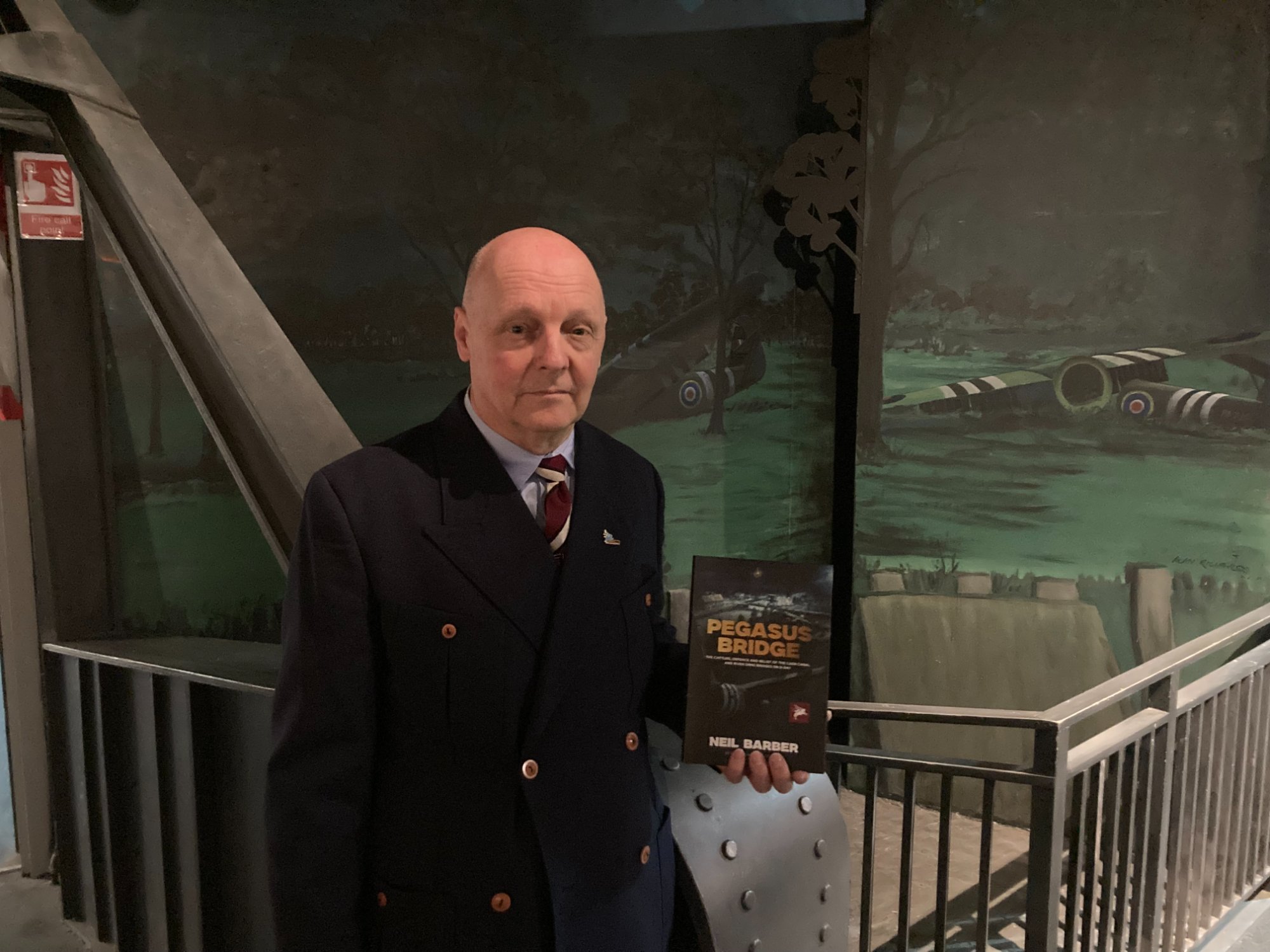 Neil Barber holding a signed copy of Pegasus Bridge